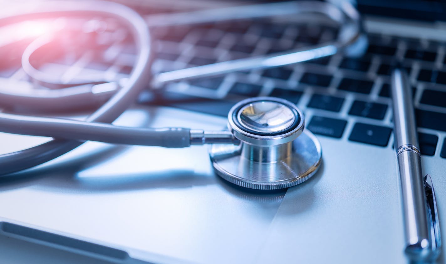 Stethoscope with pen on laptop,stethoscope for doctor check up on health medical laboratory.