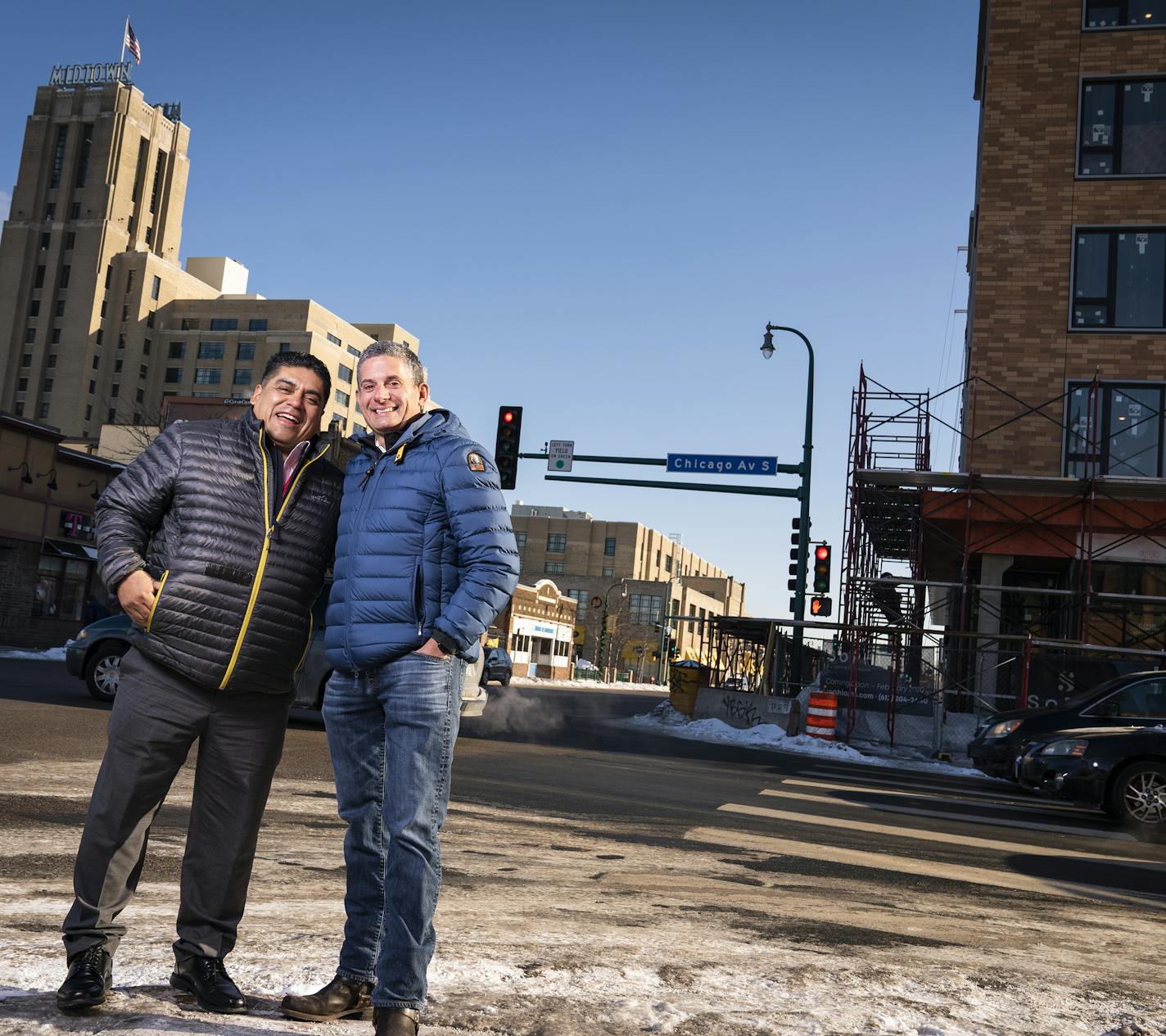 Armando Ocampo, left, and John Wolf posed for a portrait on the corner of Lake Street and Chicago Avenue in Minneapolis with the apartment building Wolf is building seen behind them on the right and Midtown Global Market seen behind them on the left. ] LEILA NAVIDI &#x2022; leila.navidi@startribune.com BACKGROUND INFORMATION: John Wolf, the owner of Chicago-Lake Liquors, posed for a portrait with restaurateur Armando Ocampo, who will be the flagship retail tenant on ground floor of the apartment