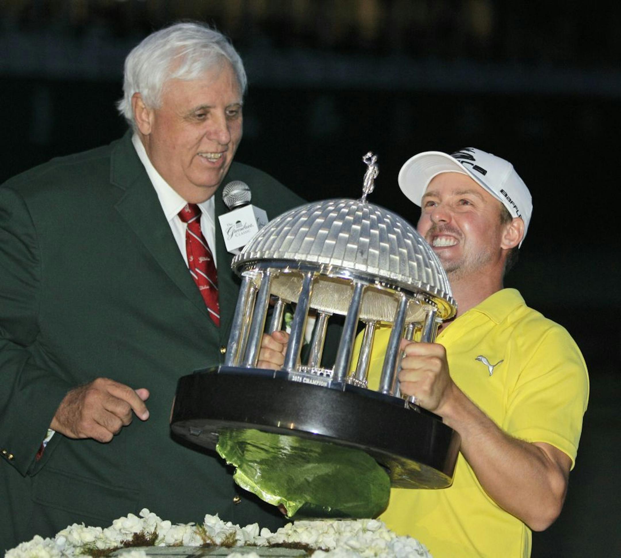 Jonas Blixt struggles to lift the trophy as Greenbrier resort owner Jim Justice, left, watches after Blixt won the Greenbrier Classic PGA golf tournament in White Sulphur Springs, W.Va., Sunday, July 7, 2013.