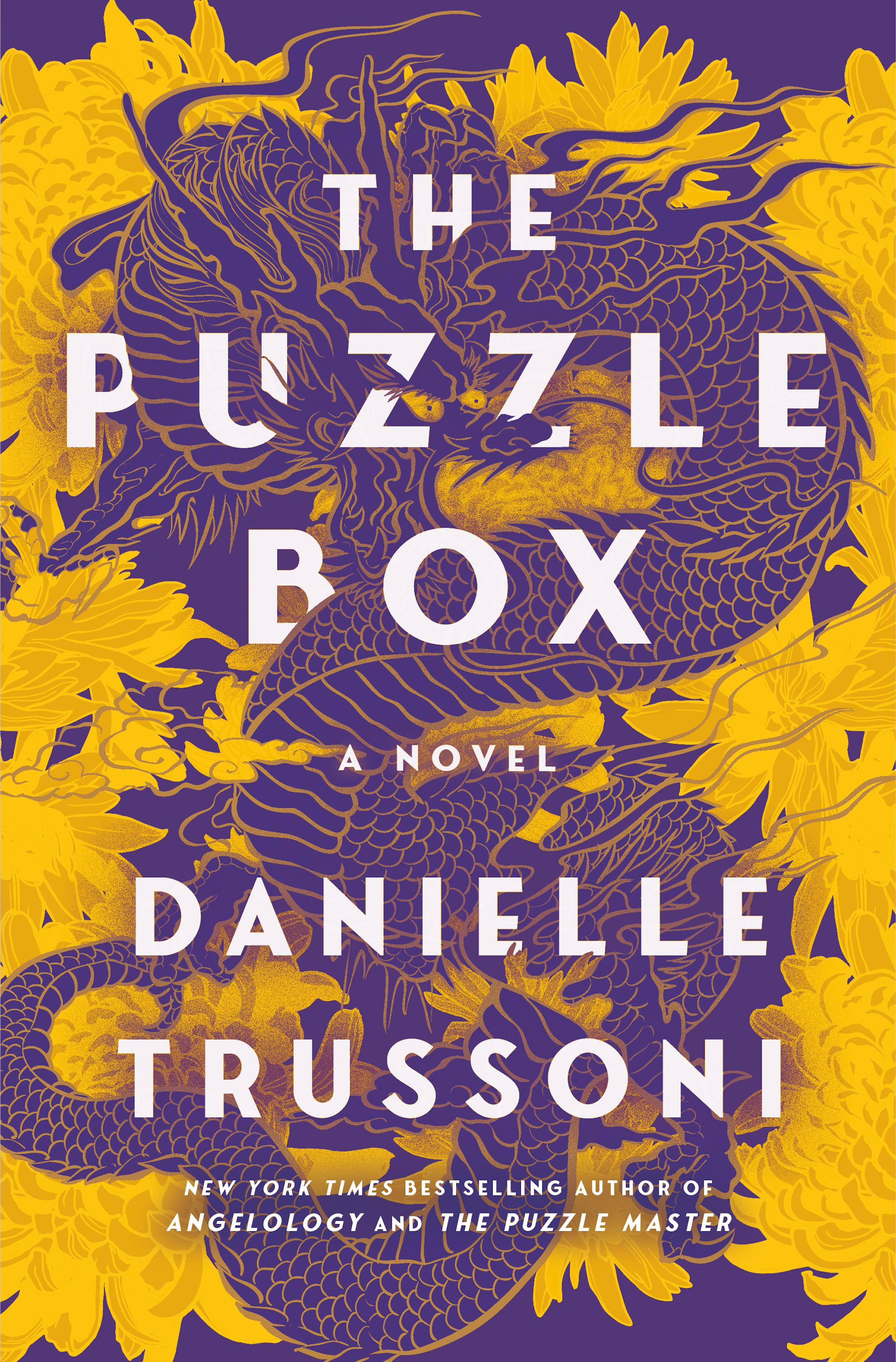 The purple and gold cover of The Puzzle Box features a drawing of a coiled dragon