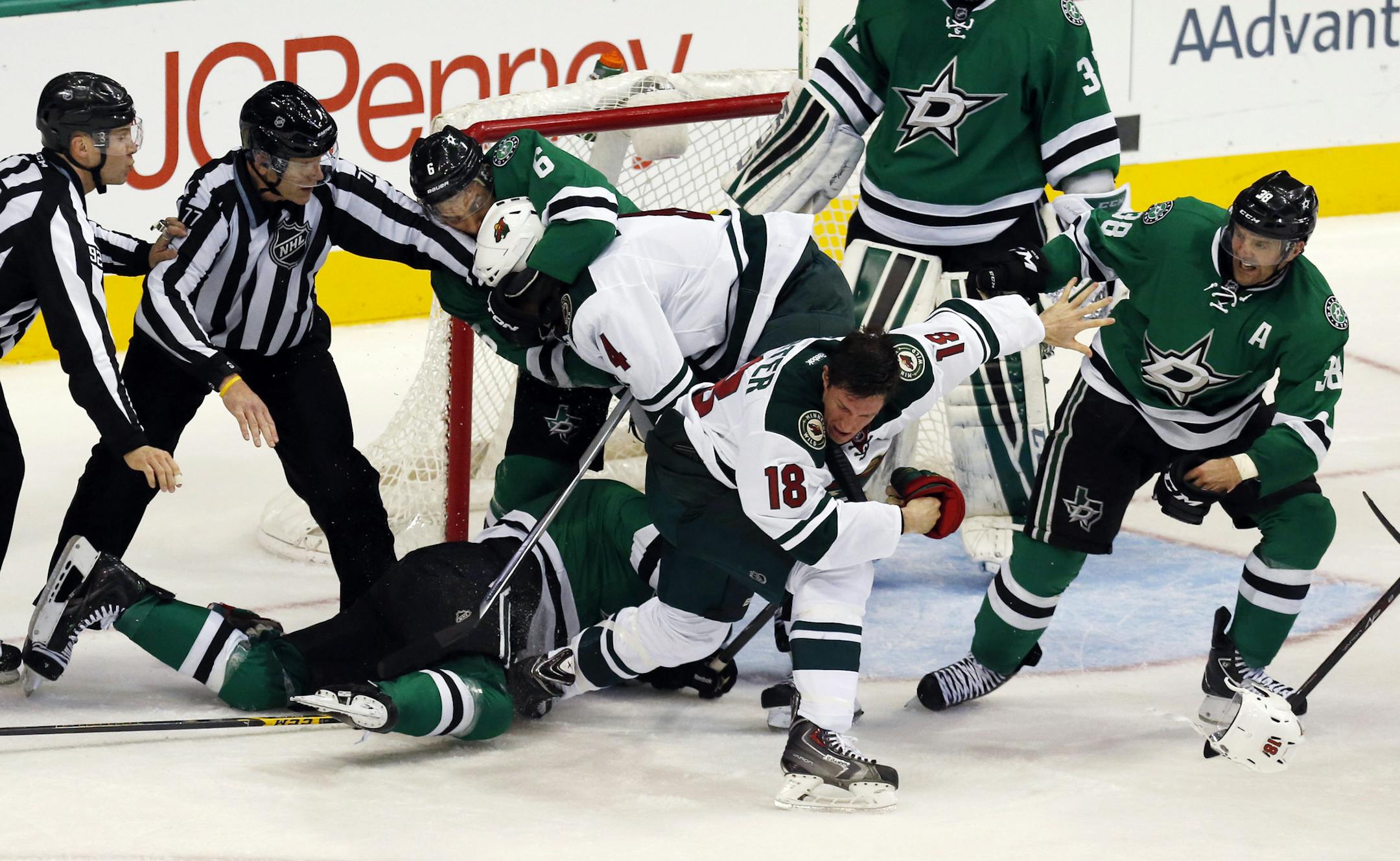 Officials try to stop Dallas Stars defenseman Trevor Daley (6), Minnesota Wild defenseman Stu Bickel (4), Wild center Ryan Carter (18) and Stars center Vernon Fiddler (38) from brawling in front of the Dallas goal during the second period of an NHL hockey game Saturday, Jan. 3, 2015, in Dallas. (AP Photo/John F. Rhodes)