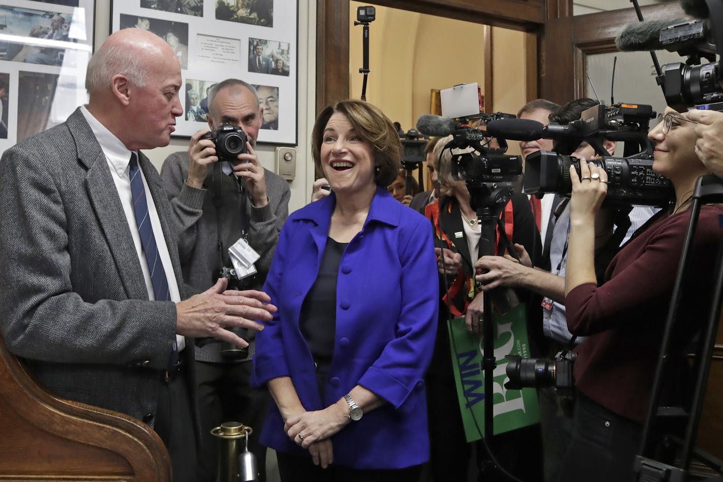 Democratic presidential candidate Sen. Amy Klobuchar, D-Minn., reacts as she chats with Secretary of State Bill Gardner, left, before filing to be listed on the New Hampshire primary ballot at the Statehouse, Wednesday, Nov. 6, 2019, in Concord, N.H. (AP Photo/Elise Amendola)