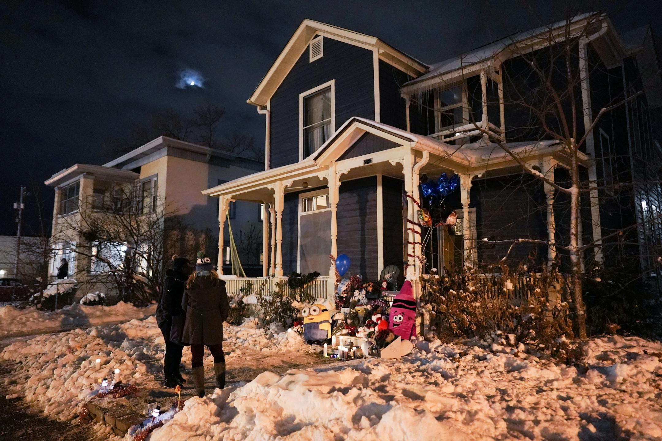 Mourners visit a vigil for slain Schladetzky family members at their home on Oakland Ave. South.