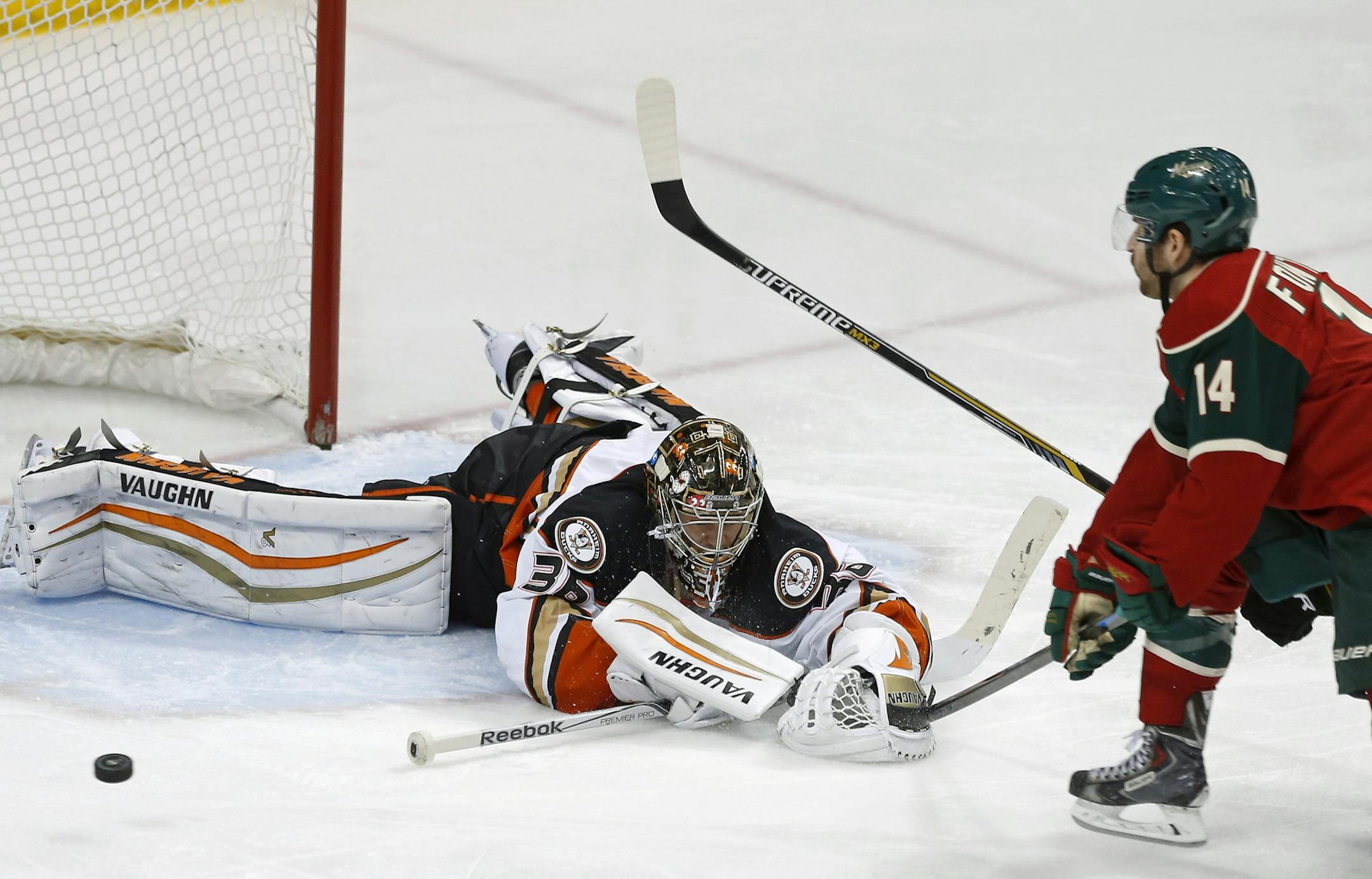 Anaheim Ducks goalie John Gibson, left, stops a shot by Minnesota Wild’s Justin Fontaine in the third period of an NHL hockey game, Friday, March 13, 2015, in St. Paul, Minn. The Ducks won 2-1. (AP Photo/Jim Mone)