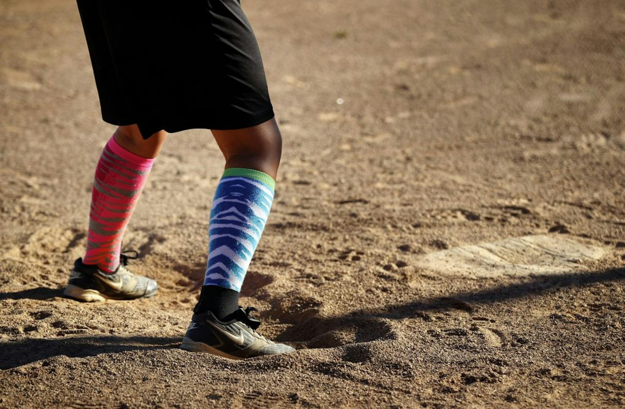 A Como girls player stood in the batters box with different colored socks during a game vs. the Phalen girls under 14 team at Como Field in St. Paul.