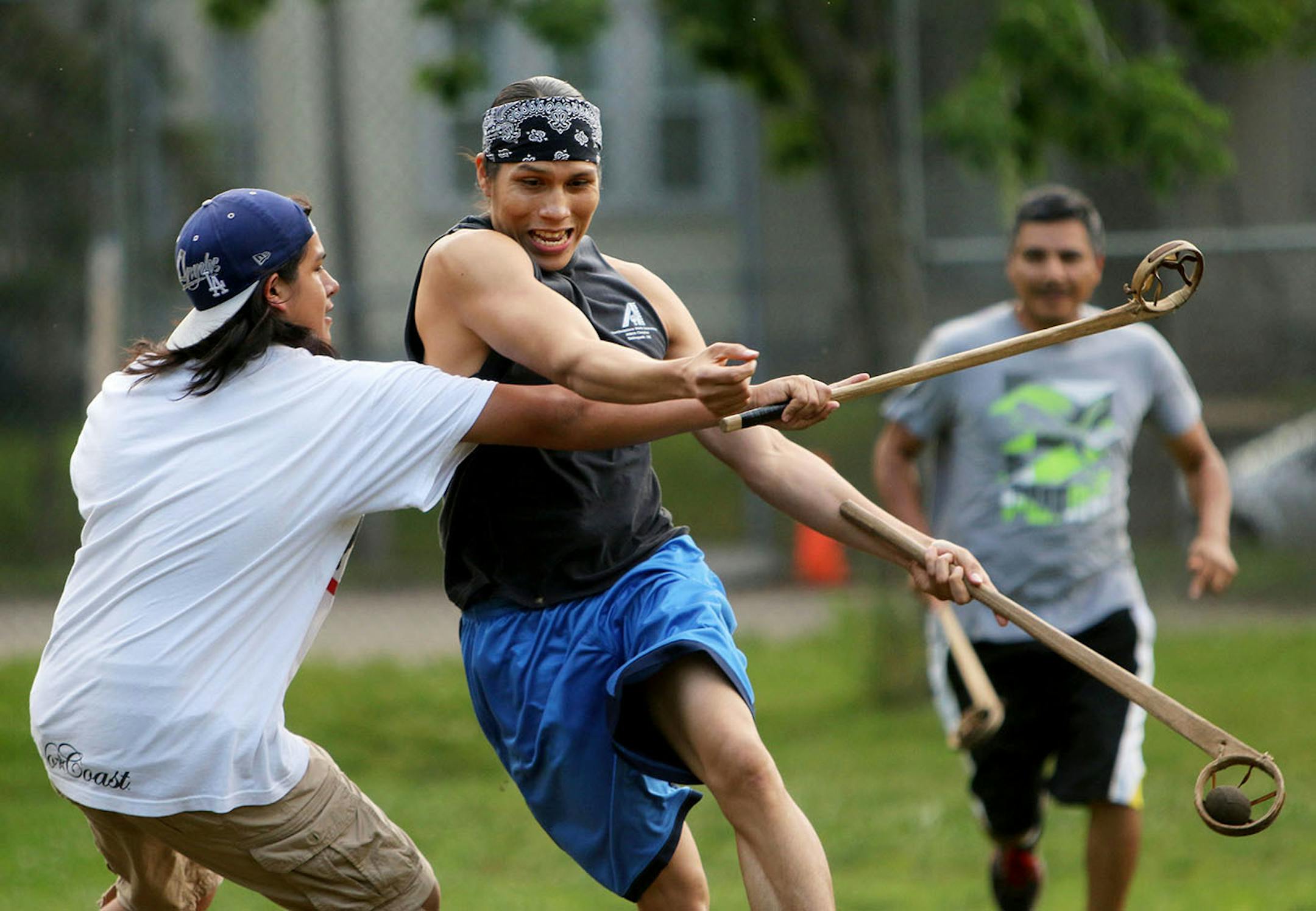 Youth members of Twin Cities Native Lacrosse practice at Corcoran Park Wednesday, June 17, 2015, in Minneapolis, MN. The traditional Lacrosse players, who play with hand carved ash sticks, were preparing for the upcoming Twin Cities Native Lacrosse Tournament at the Osseo High School Saturday. Here, Russel Harjo moves the ball upfield covered by Javier Yanez, left, with Danny Polk, right, trailing.