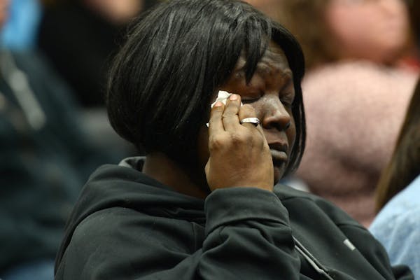 Tammy Gipson, of St. Paul, wiped away tears during a moment of silence called for by a public commenter for a John Broyles, a 17-year old Como High se