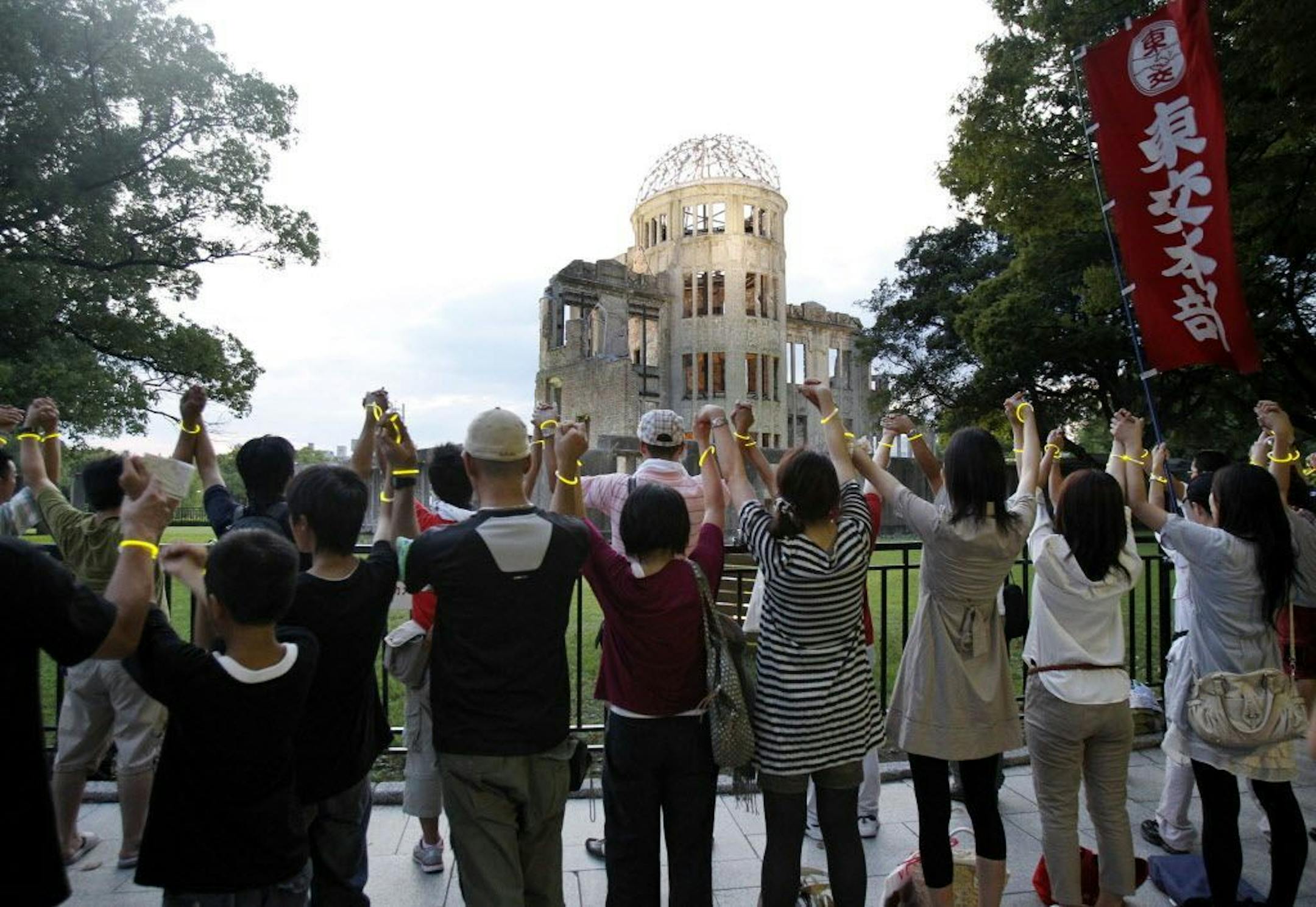 Anti-nuclear demonstrators form a human chain in front of the Atomic Bomb Dome in Hiroshima, western Japan, on the eve of the 66th anniversary of the world's first atomic bombing on the city Friday, Aug. 5, 2011.