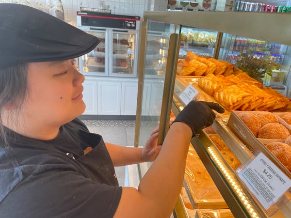 I Chang, one of the managers at the Tous les Jours in Richfield, straightens up the pastry shelves.