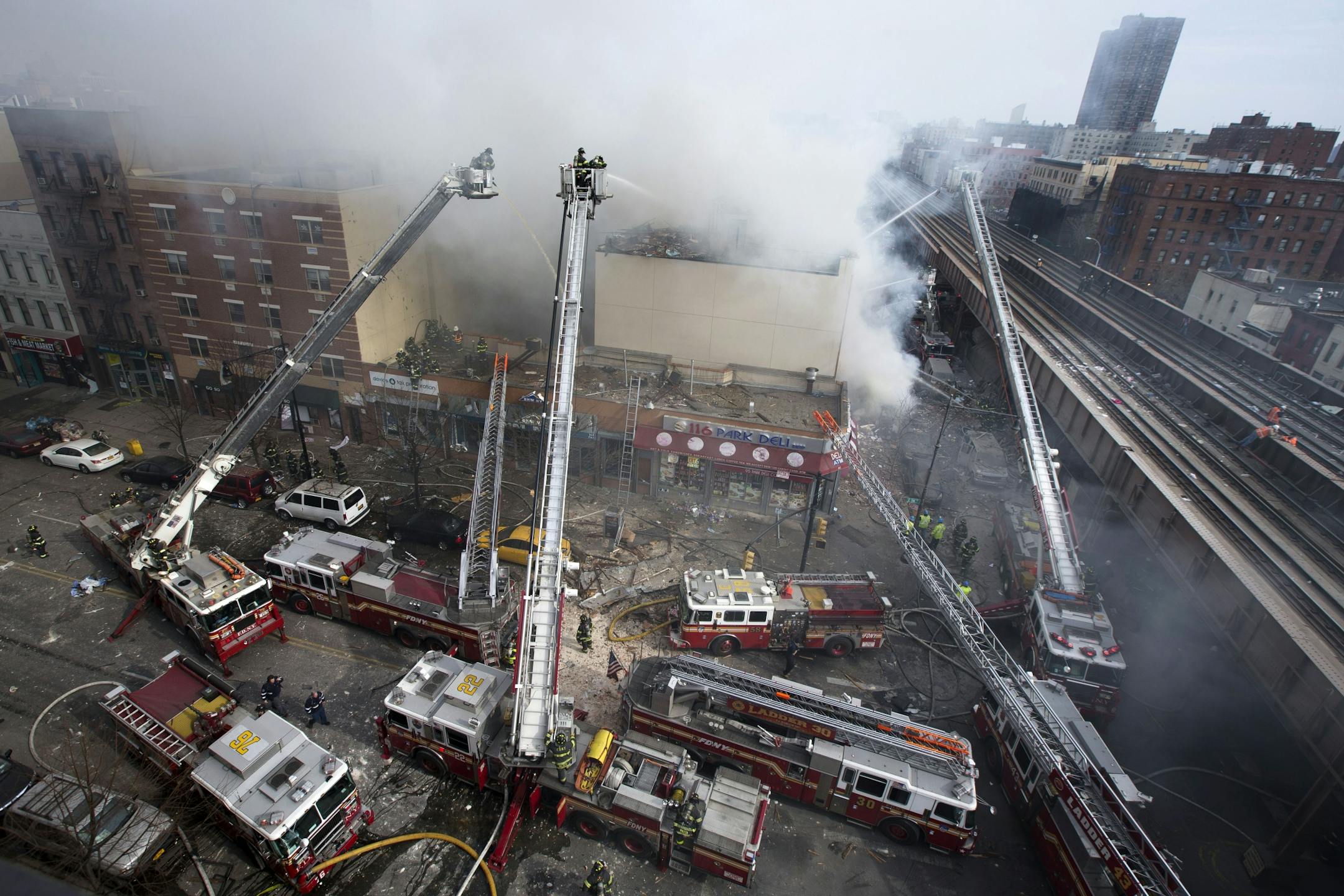 Firefighters battle a fire after a building collapses in the East Harlem neighborhood of New York, Wednesday, March 12, 2014
