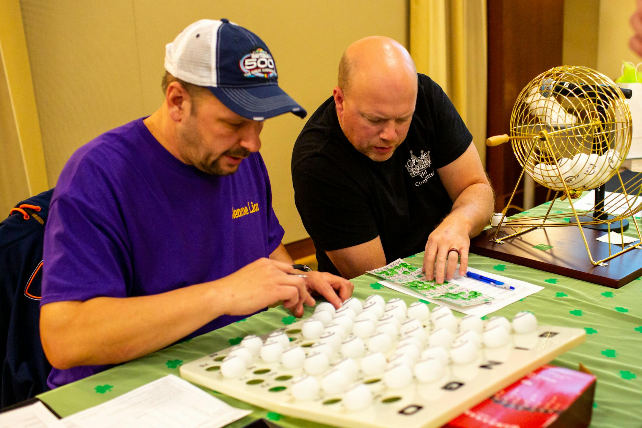 Jason Dahlke and Todd Breyer check a bingo card during Designer Purse &amp; Gun Bingo.