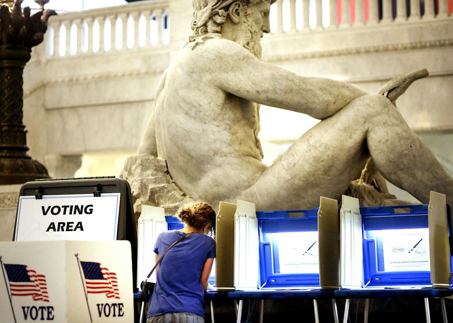 With the Father of Waters sculpture looming to her rear, Kym Spotts of Minneapolis completes her absentee ballot at the Minneapolis City Hall Friday, Aug. 8, 2014, in Minneapolis, MN. Spotts, who said she will be out of town on Tuesday, said she requested the absentee ballot form but received the wrong form in the mail and it turned into a "wild goose chase."] (DAVID JOLES/STARTRIBUNE) djoles@startribune A heated primaries have drawn an outpouring of absentee ballots in the first race where vote