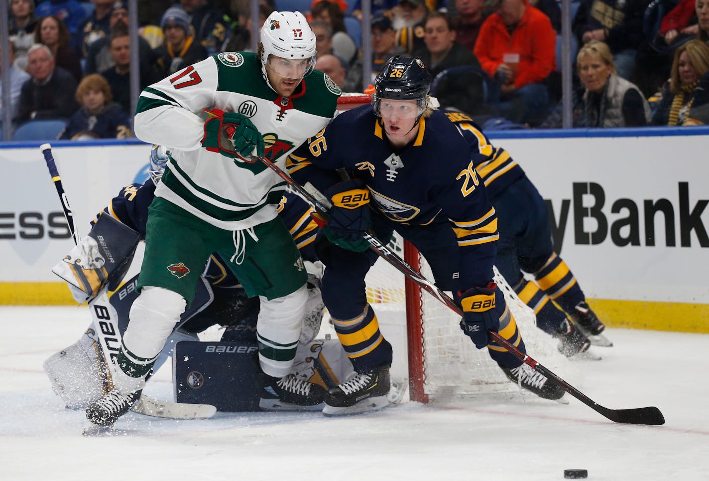 Buffalo Sabres defenseman Rasmus Dahlin, right, and Minnesota Wild forward Marcus Foligno, left, battle for the puck during the second period of an NHL hockey game, Tuesday, Feb. 5, 2019, in Buffalo N.Y. (AP Photo/Jeffrey T. Barnes)