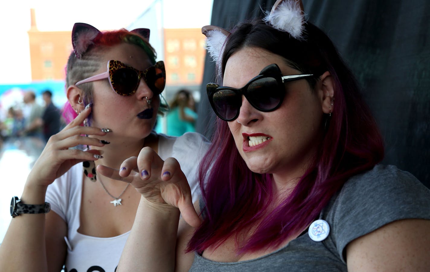 Lacie Zeiler, of Minneapolis, right and Renata Shaffer-Gottschalk make cat faces before the start of the Cat Video Festival hosted by the Walker Arts Center. ] (KYNDELL HARKNESS/STAR TRIBUNE) kyndell.harkness@startribune.com Cat video festival at CHS Field in St Pauls, Min., Wednesday August 12, 2015.