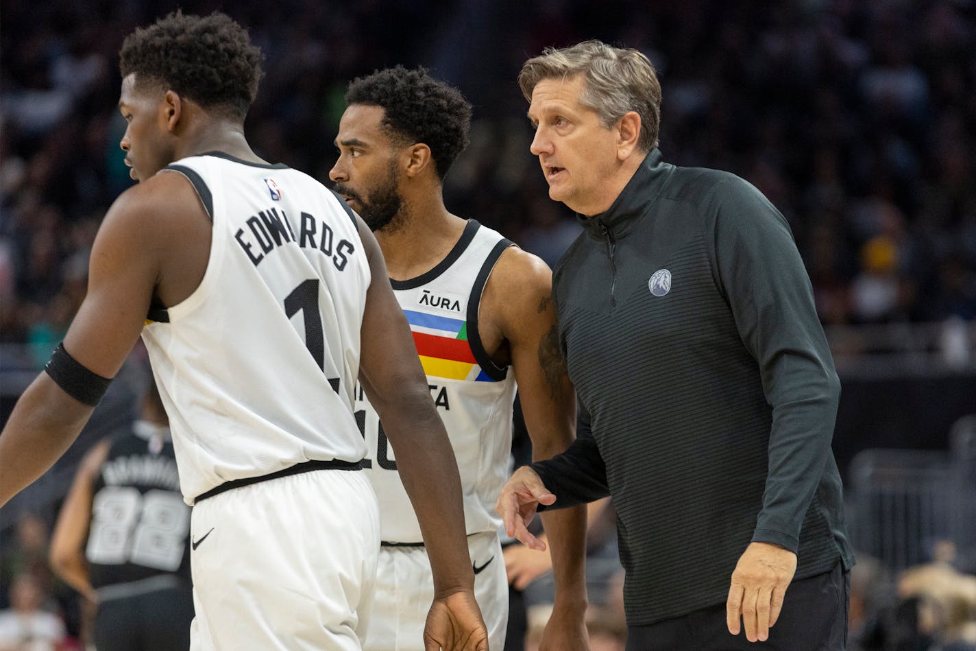 Minnesota Timberwolves head coach Chris Finch, right, speaks with guards Mike Conley, center, and Anthony Edwards, left, during the first half of an NBA basketball game against the San Antonio Spurs, Saturday, April 8, 2023, in Austin, Texas. (AP Photo/Stephen Spillman)