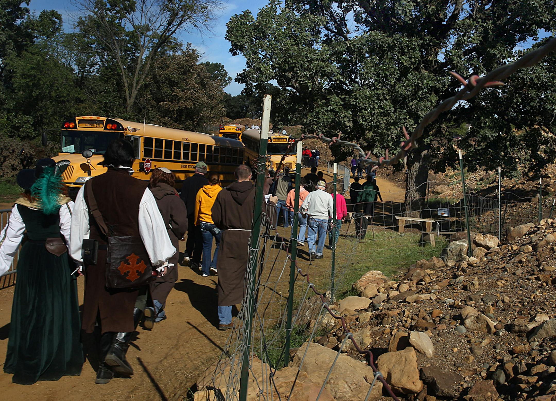 Patrons walk along a path that circumvents a large mining site, as they head toward the Renaissance Festival grounds. ] JIM GEHRZ ‚Ä¢ jgehrz@startribune.com / Shakopee, MN / Sept. 13, 2014 / 8:30 AM / BACKGROUND INFORMATION: For decades the Renaissance Festival has been trying to maintain an illusion of a return to a distant medieval past. But recent patrons report that the illusion is under strain, as a very modern-day enterprise, sand mining for oil fracking, is visibly gnawin