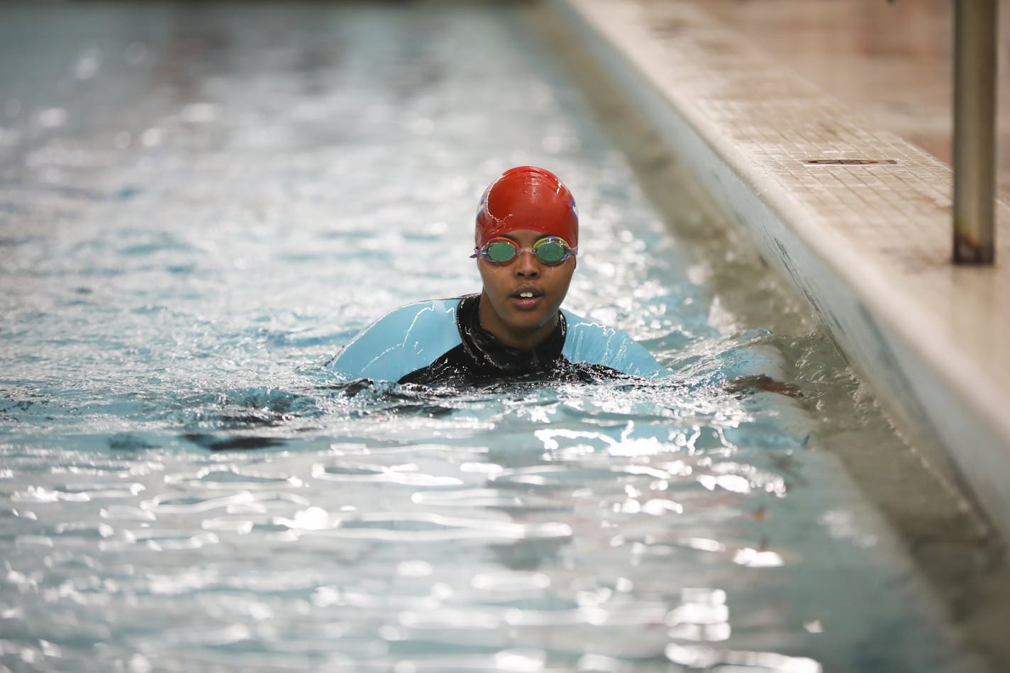 Suhan Mohamed in the pool warming up before a swim meet at Apollo High School in St. Cloud, Minn., on Thursday, October 5, 2017. Nimo Gohe (not pictured) and Suhan Mohamed just learned to swim this summer and are now on the Apollo High School swim team.