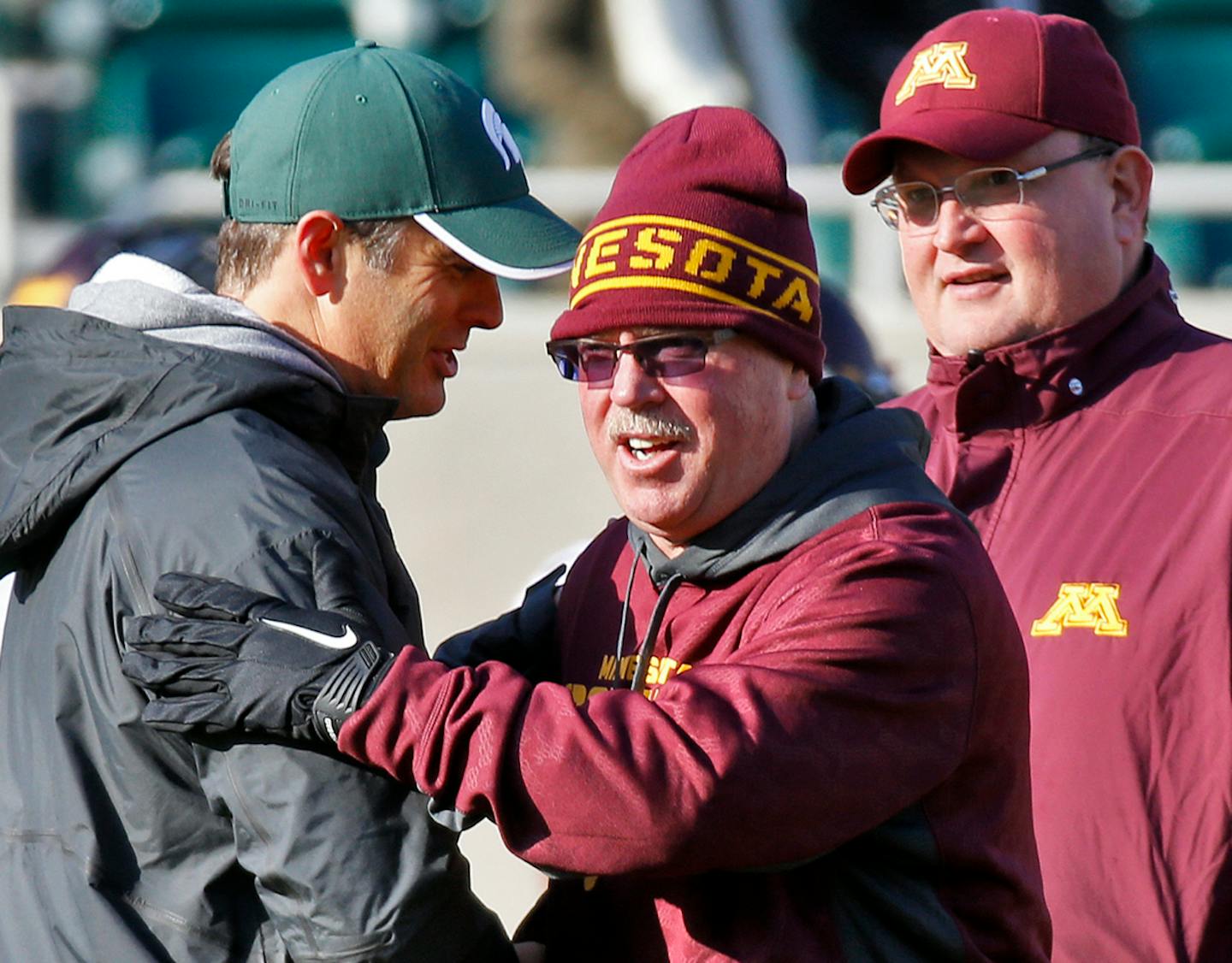 Jerry Kill, center, and Tracy Claeys (right) before a game against Michigan State in 2013.