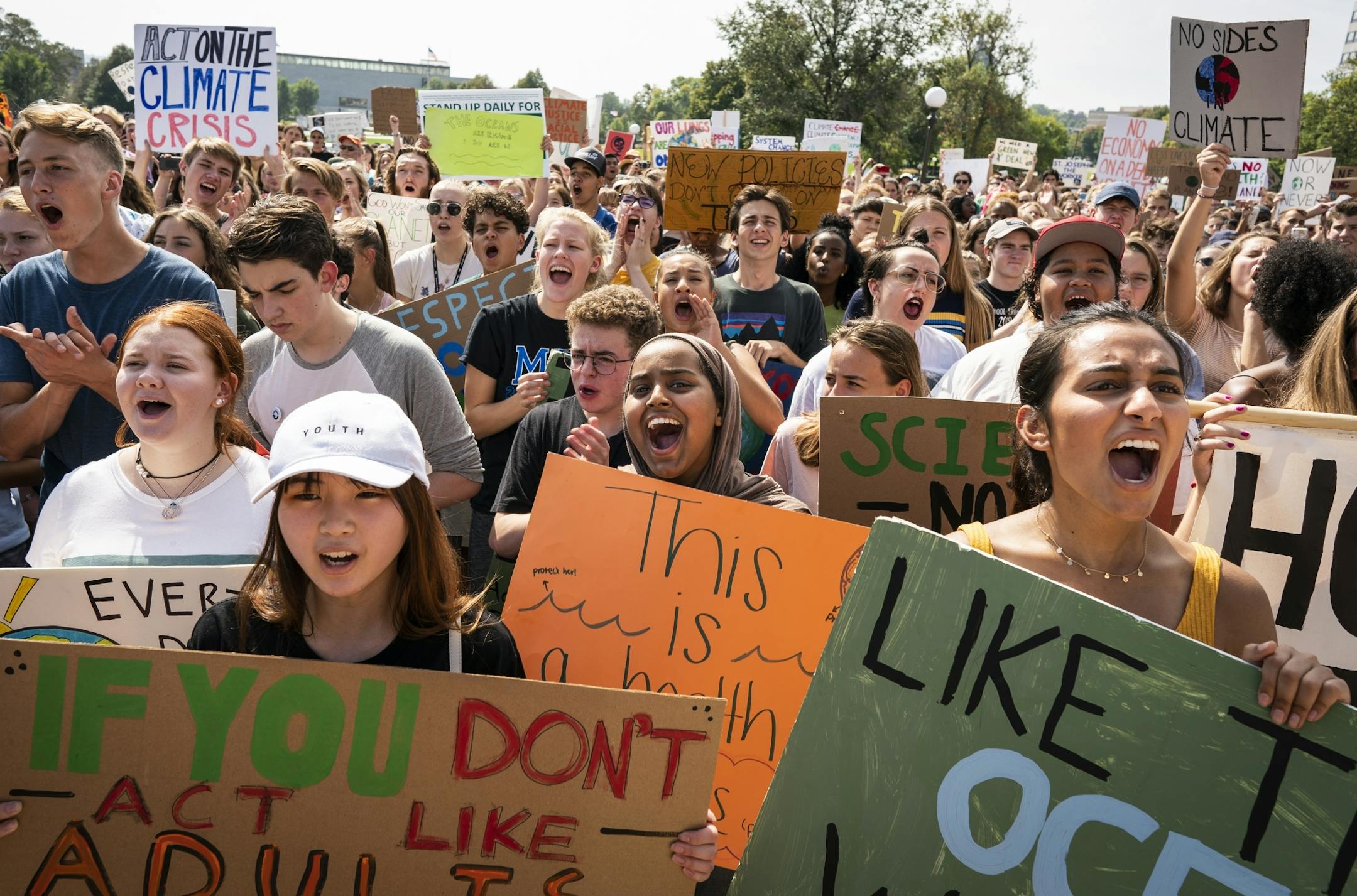 Protesters Amanda Khouw, from left in white hat, 17, of Woodbury, Nasri Maktal, 17, of Maplewood, and Meera Dear, 17, of Shoreview cheered during the rally at the Capitol.