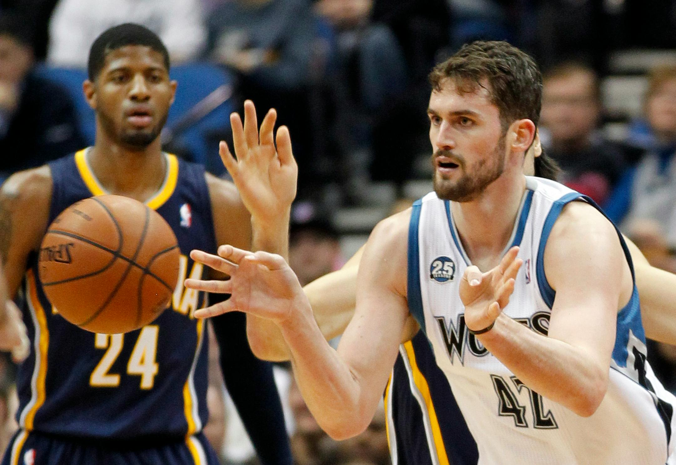Minnesota Timberwolves forward Kevin Love (42) makes a pass with Indiana Pacers forward Paul George (24) watching during the first half of their NBA basketball game, Wednesday, Feb. 19, 2014 in Minneapolis. (AP Photo/Andy Clayton-King)