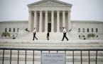 Officers with the U.S. Supreme Court walk along a fenced-off plaza during early morning hours at the Supreme Court in Washington, May 3. A leaked draf