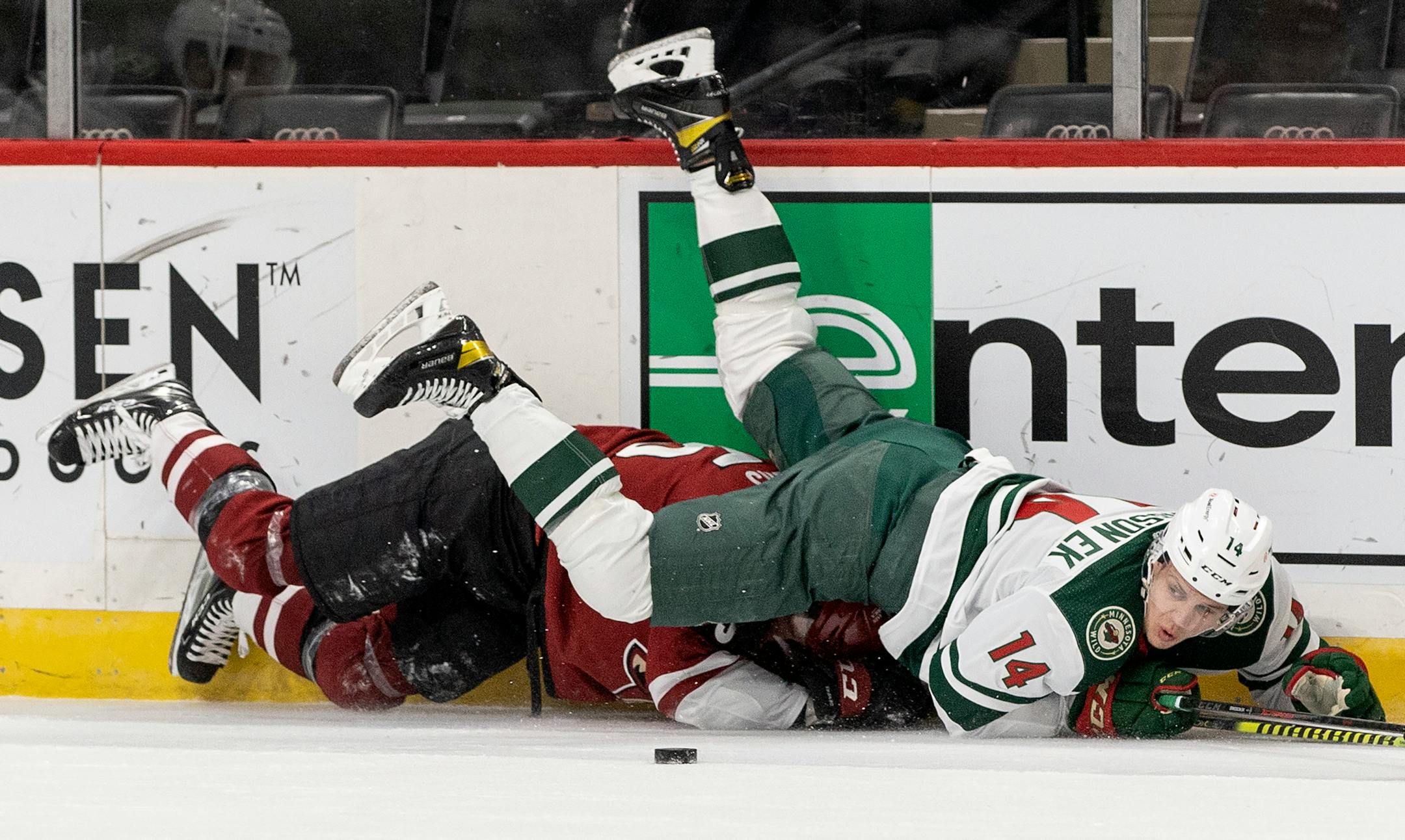 Joel Eriksson Ek (14) of the Minnesota Wild got tangled up with Jason Demers (55) of the Arizona Coyotes in the first period.