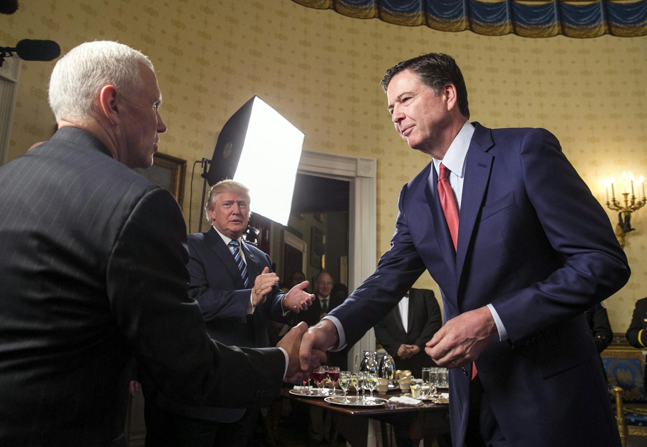 FILE -- FBI Director James Comey greets Vice President Mike Pence and President Donald Trump during a reception at the White House in Washington, Jan. 22, 2017. Comey believes that a one-on-one dinner with Trump seven days after the inauguration, in which the president asked if Comey would pledge loyalty to him, was a harbinger of his firing, according to two people who have heard Comey’s account of the conversation. The White House disputes this account. (Al Drago/The New York Times)