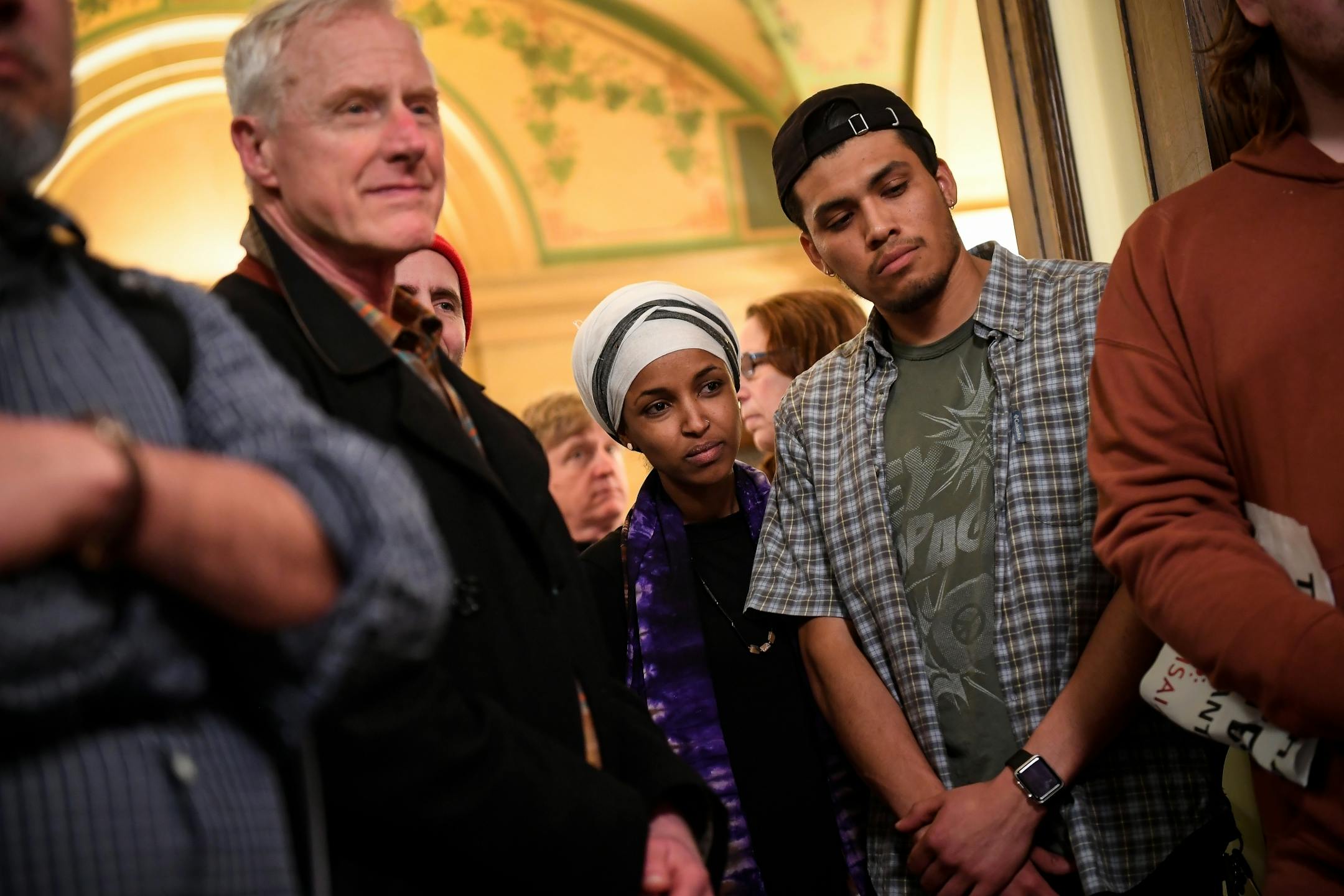 Rep. Ilhan Omar, center, of Minneapolis, listened in on a n immigration rights protest occupying the lobby of Gov. Mark Dayton's office Tuesday evening.
