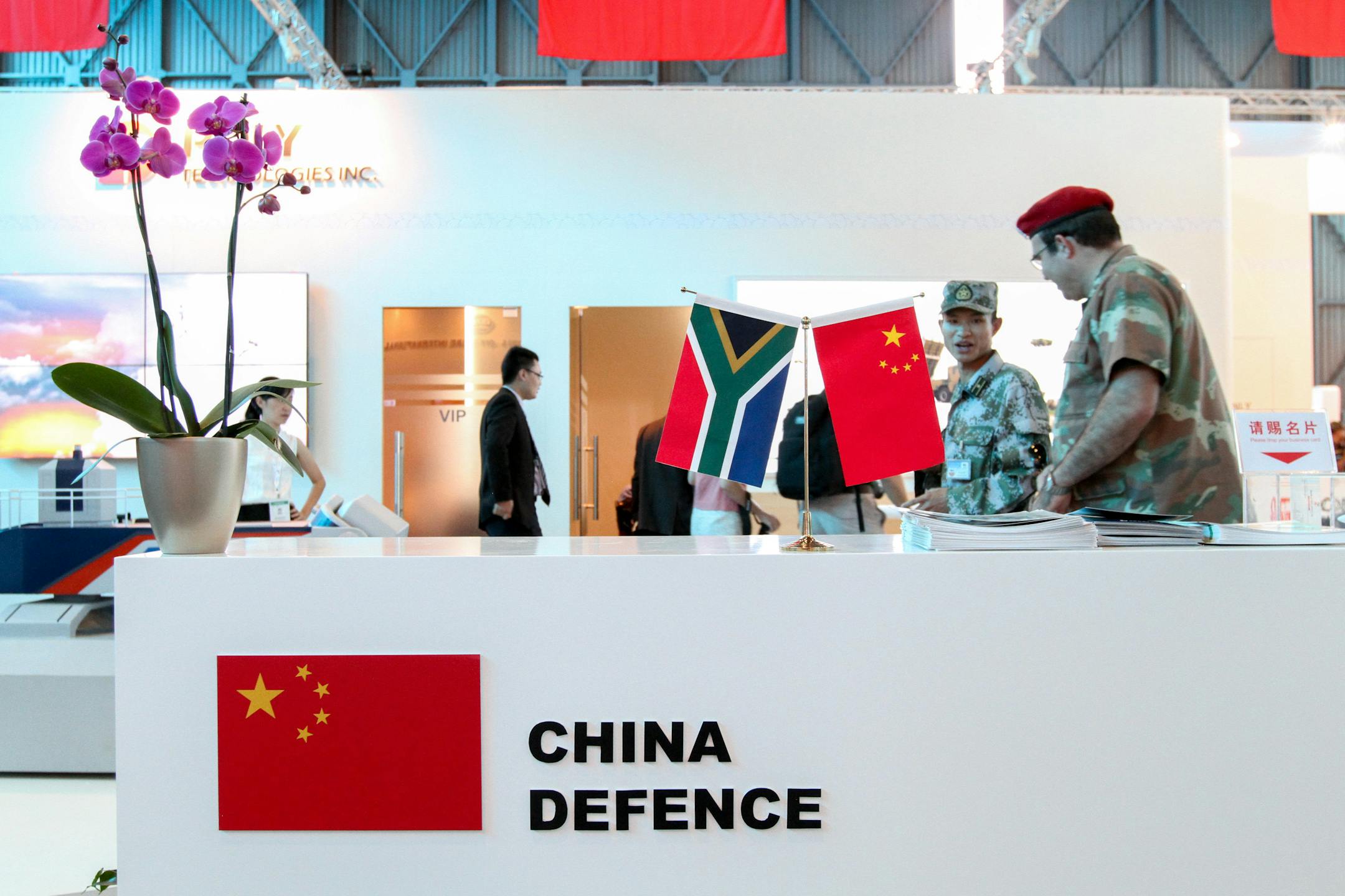 Mini South African, left, and Chinese national flags stand on a reception desk at the China Defence trade stand during the Africa Aerospace & Defence Show (AAD2014) at the Waterkloof Air Force Base in Pretoria, South Africa, on Thursday, Sept. 18, 2014. China is selling $38 million worth of missiles, grenade launchers, machine guns and ammunition to South Sudan's government, even as it pledges to help end a civil war in the country now on the brink of famine. Photographer: Dean Hutton/Bloomberg