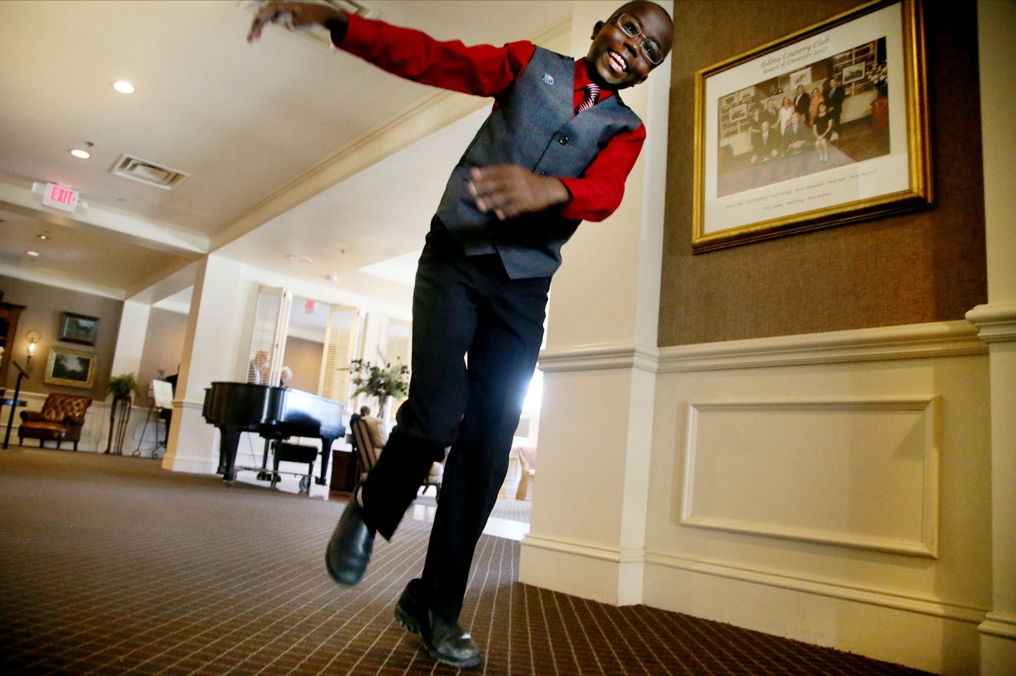 The Edina Rotary Club is having a 13th birthday celebration for Moses Mwaura, the young Kenyan boy they sponsored, who received corrective eye and teeth surgery and who is back in Edina for the first time in 7 years. Here, Moses, who loves music and plays several instruments, skips away after looking over a piano Thursday, Dec. 7, 2017, at the Edina Country Club in Edina, MN.