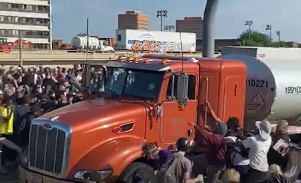 Protesters climbed on a fuel truck after it came to a stop on the I-35W bridge over the Mississippi River in Minneapolis on Sunday.