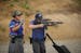 Jonah Klevesahl fired on targets with an AR-15 while he was monitored and timed by Gunnar An during 3 gun league competition Wednesday night. ] JEFF W