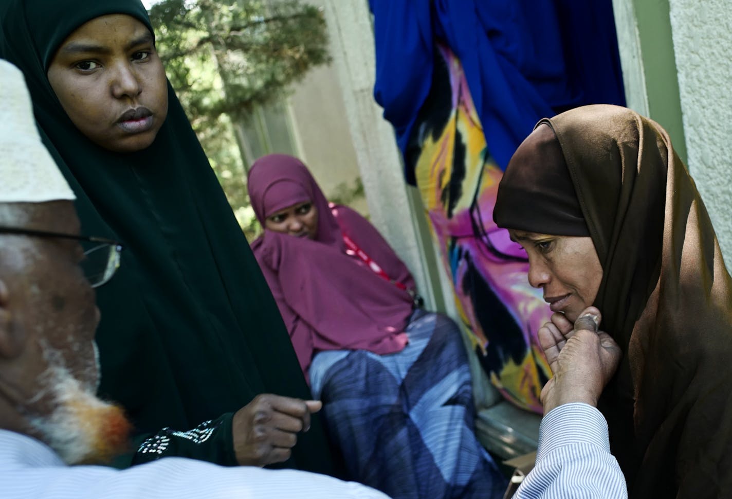 Lul Mohamed, far right, grieved for her son Ahmed Sahane Hashi, 11, who drowned along with childhood friend Idris Hussein,10, at nearby Foot Lake.