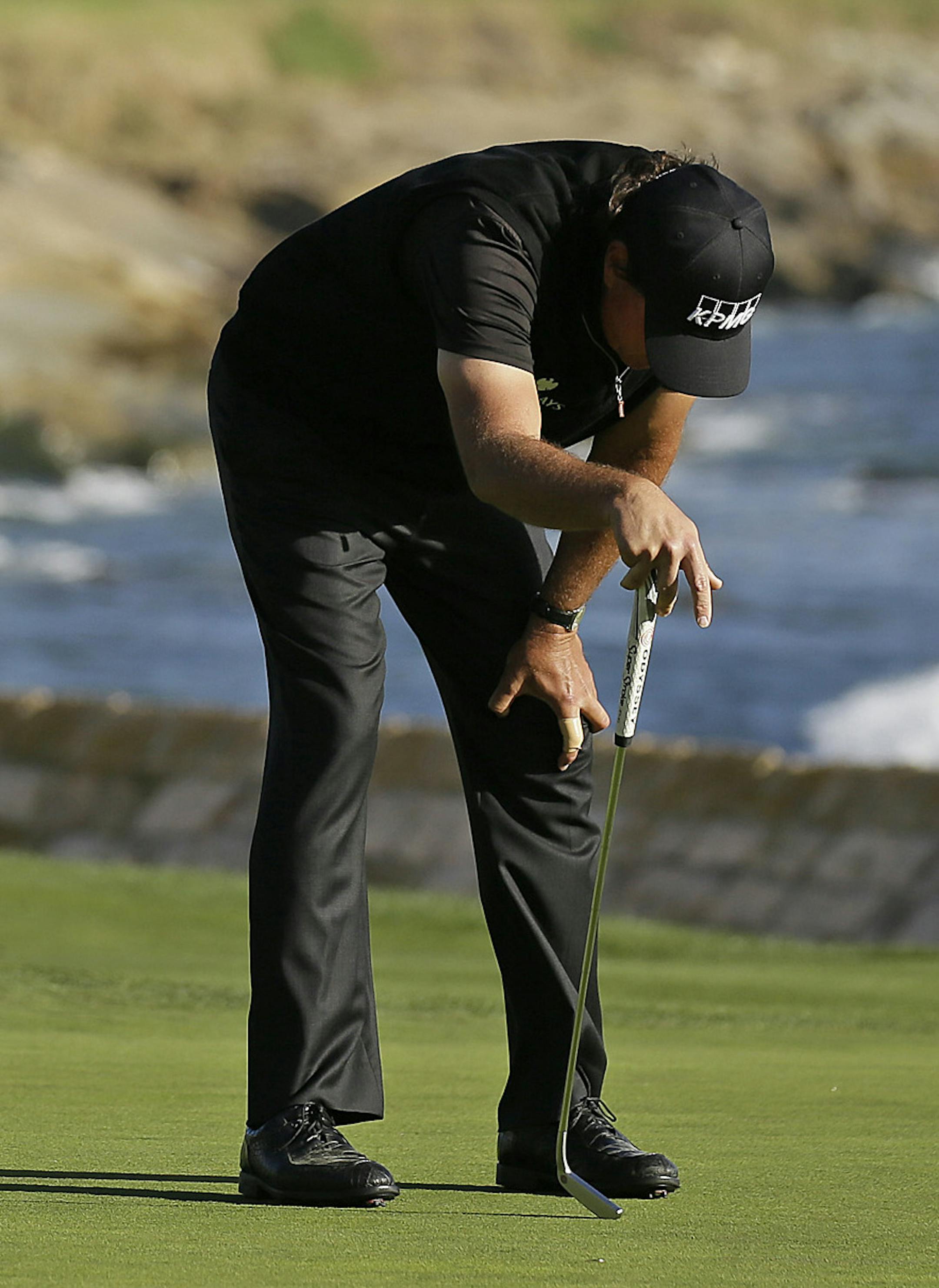 Phil Mickelson reacts after missing a birdie putt on the 18th green of the Pebble Beach Golf Links during the final round of the AT&T Pebble Beach National Pro-Am golf tournament Sunday, Feb. 14, 2016, in Pebble Beach, Calif. Vaughn Taylor won the tournament by one stroke over Mickelson. (AP Photo/Eric Risberg)