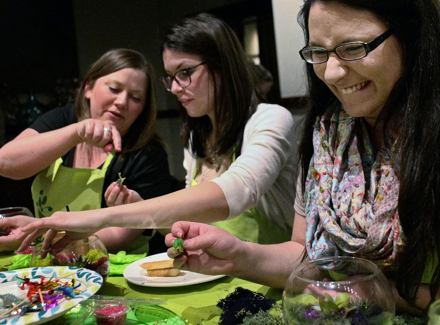 Left to right, Angela Edenloffy, Liz Gunderson, and Tina Northrop-Day finish off their terrariums with tiny windmills.