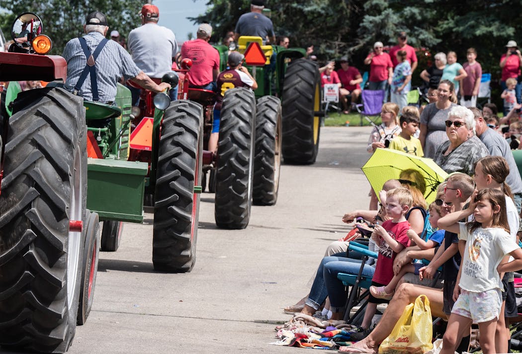 A fleet of tractors pass by parade-goers at the Gopher Count festival in Viola on Thursday. 