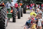 A fleet of tractors pass by parade goers at the Gopher Count festival in Viola on Thursday. 