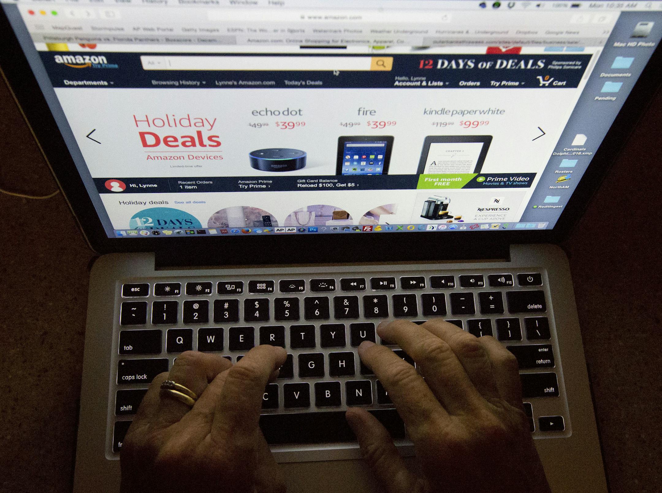 FILE - In this Monday, Dec. 12, 2016, file photo, an online shopper searches a site. On Tuesday, Nov. 28, 2017, the National Retail Federation estimated that people who shopped both online and in stores from Thanksgiving to Cyber Monday, spent more than those who stuck to one or the other. (AP Photo/Wilfredo Lee, File)