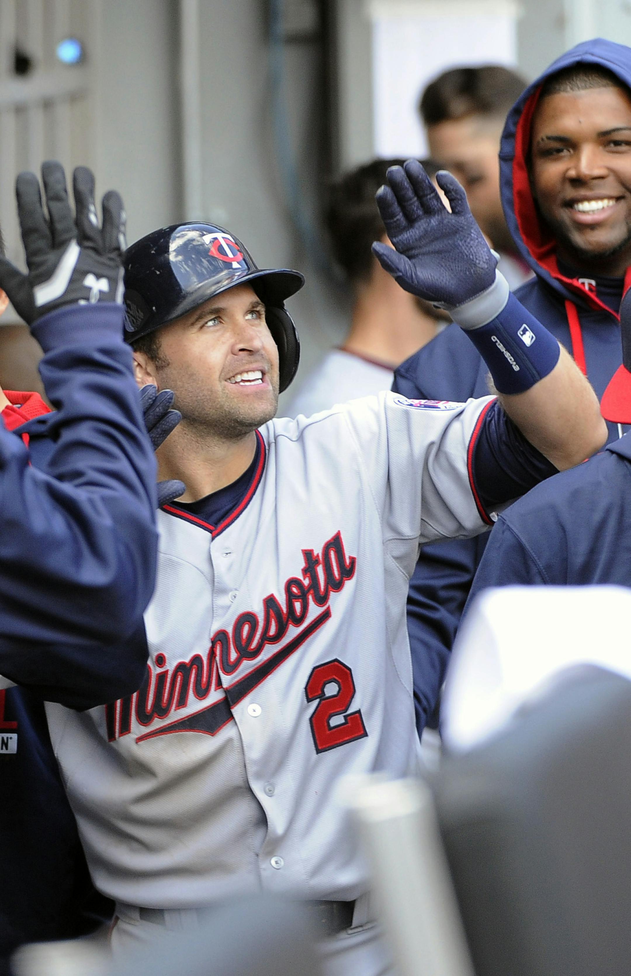 Minnesota Twins second baseman Brian Dozier (2) is greeted by teammates after hitting a home run against the Chicago White Sox during the sixth inning of a baseball game, Friday, April 10, 2015 in Chicago. (AP Photo/David Banks)