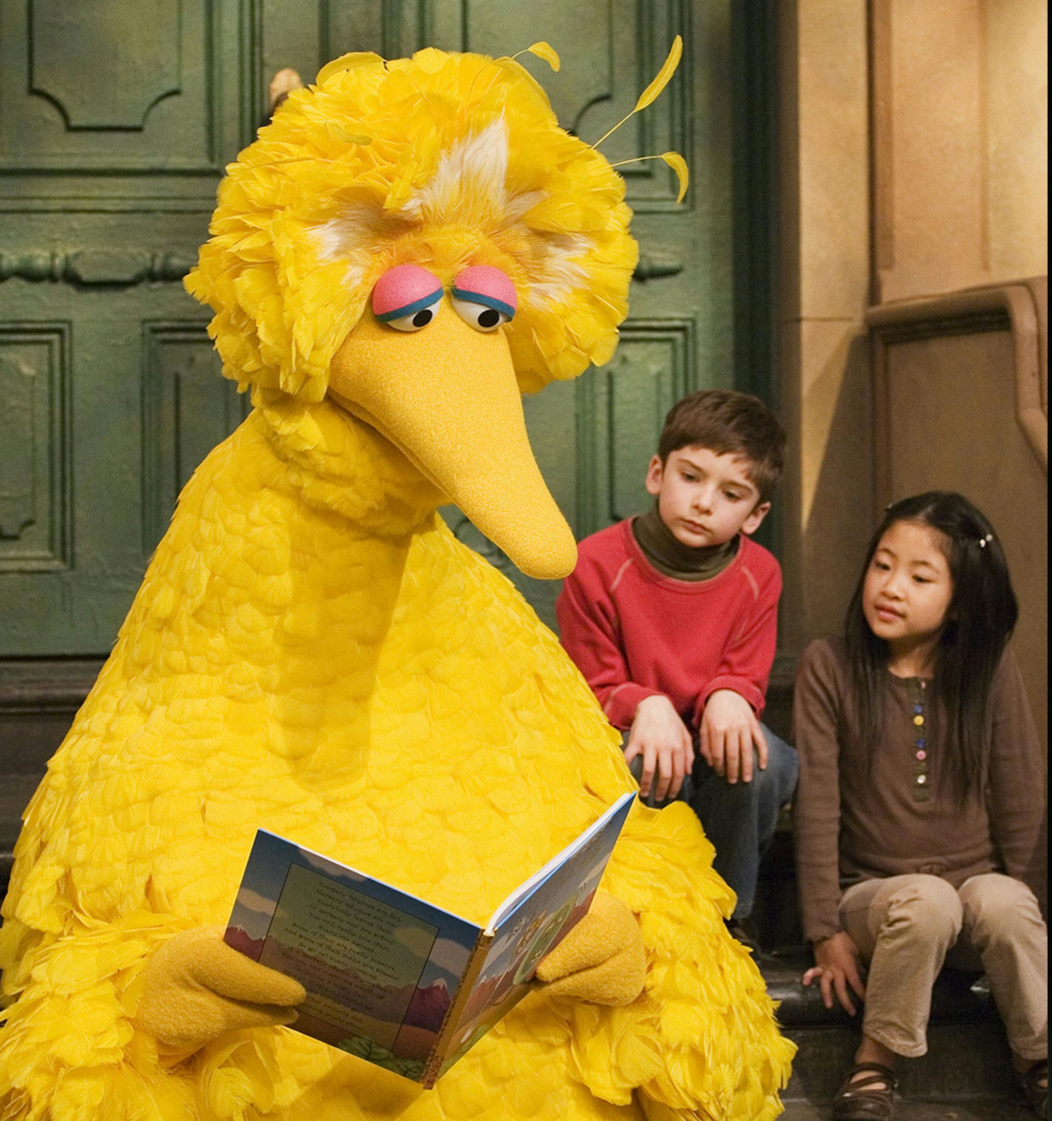FILE - In this April 10, 2008 file photo, muppet character Big Bird reads to Connor Scott and Tiffany Jiao during a taping of the children's program "Sesame Street" in New York. Sesame Street continues to attract millions of viewers after 45 years on the air, appealing to both preschoolers and their parents with content that is educational and entertaining. The show has kept up with the times by making its segments faster-paced, by fine-tuning messages, and by keeping a steady flow of appearance