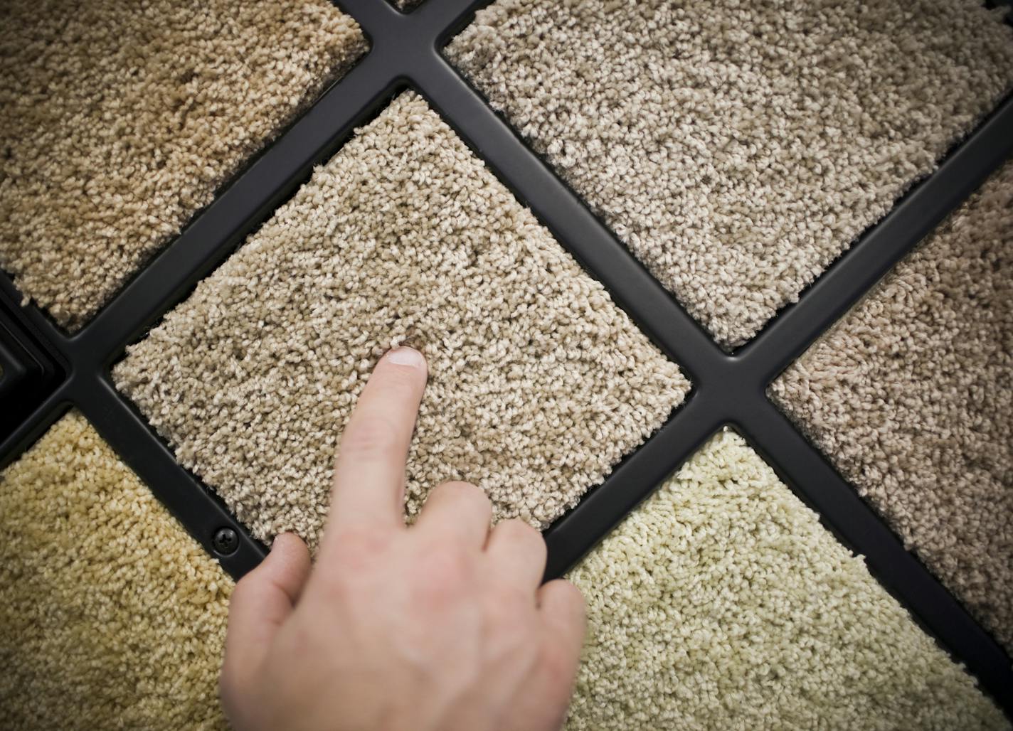 A man touches a sample of carpet