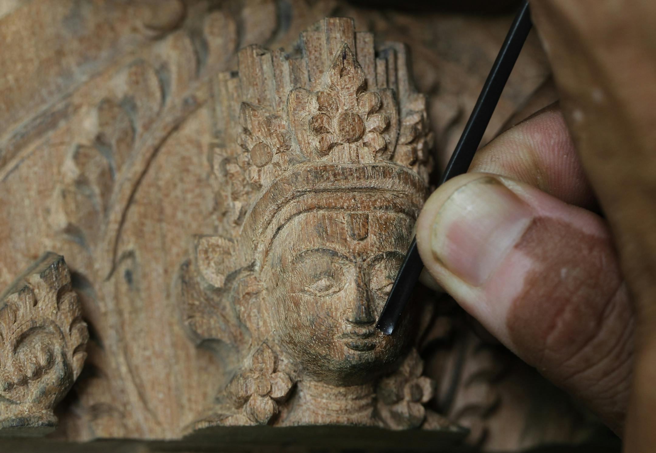 In this photo taken Thursday, July 20, 2017, a woodworker from the Newar ethnic community carves wood in Lalitput, Nepal. In the rubble of Nepal's 2015 earthquake, a team of dedicated woodworkers is finding inspiration to recreate what was lost. Centuries-old Char Narayan and Hari Shankara temples were completely destroyed by the massive April 2015 earthquake that shook the Himalayan nation, killing nearly 9,000 people. The temples were the jewel of the Patar Durbar Square, which is thronged by