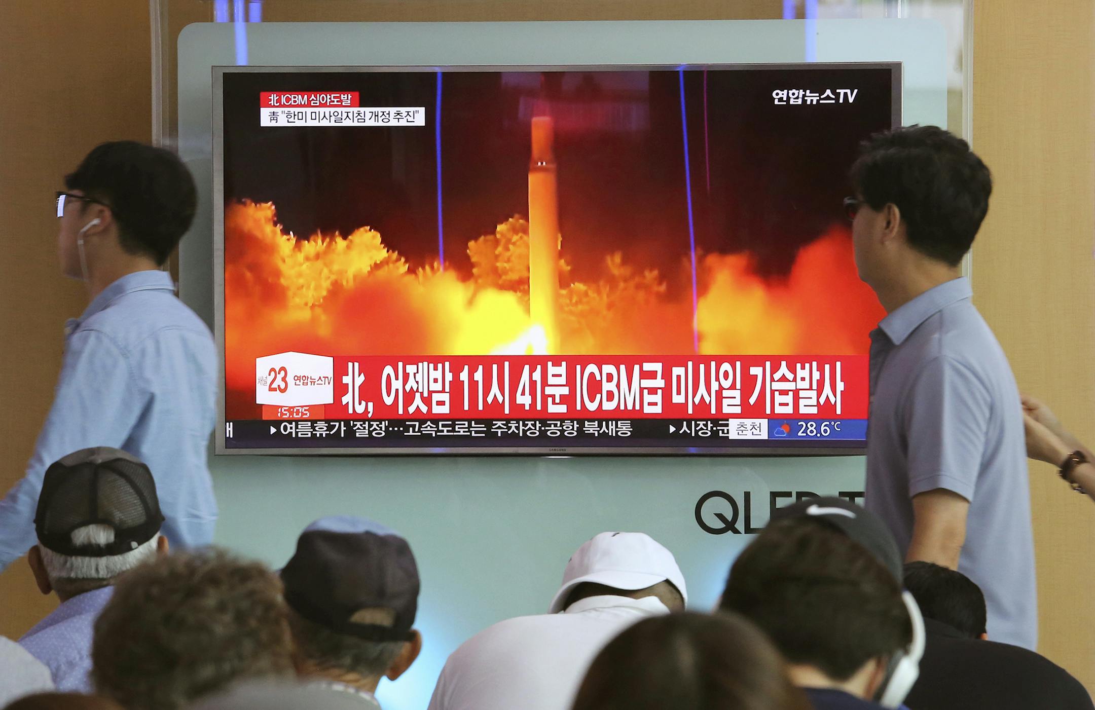 FILE - In this Saturday, July 29, 2017 photo, People watch a TV news program showing an image of North Korea's latest test launch of an intercontinental ballistic missile (ICBM), at the Seoul Railway Station in Seoul, South Korea. South Korea's latest leader Moon Jae-in told U.S. President Donald Trump he's happy to talk about North Korea's ICBM test but after his vacation. It might seem like an oddly timed break for a relatively new president during his country's biggest crisis. The signs read