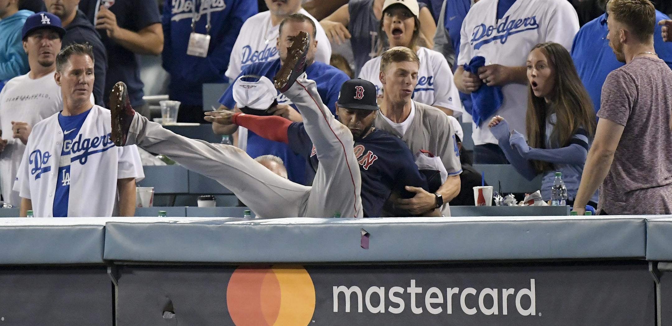 Boston Red Sox third baseman Eduardo Nunez falls into the stands after catching a foul ball hit by Los Angeles Dodgers' Cody Bellinger during the 13th inning in Game 3 of the World Series baseball game on Friday, Oct. 26, 2018, in Los Angeles. (AP Photo/Mark J. Terrill)