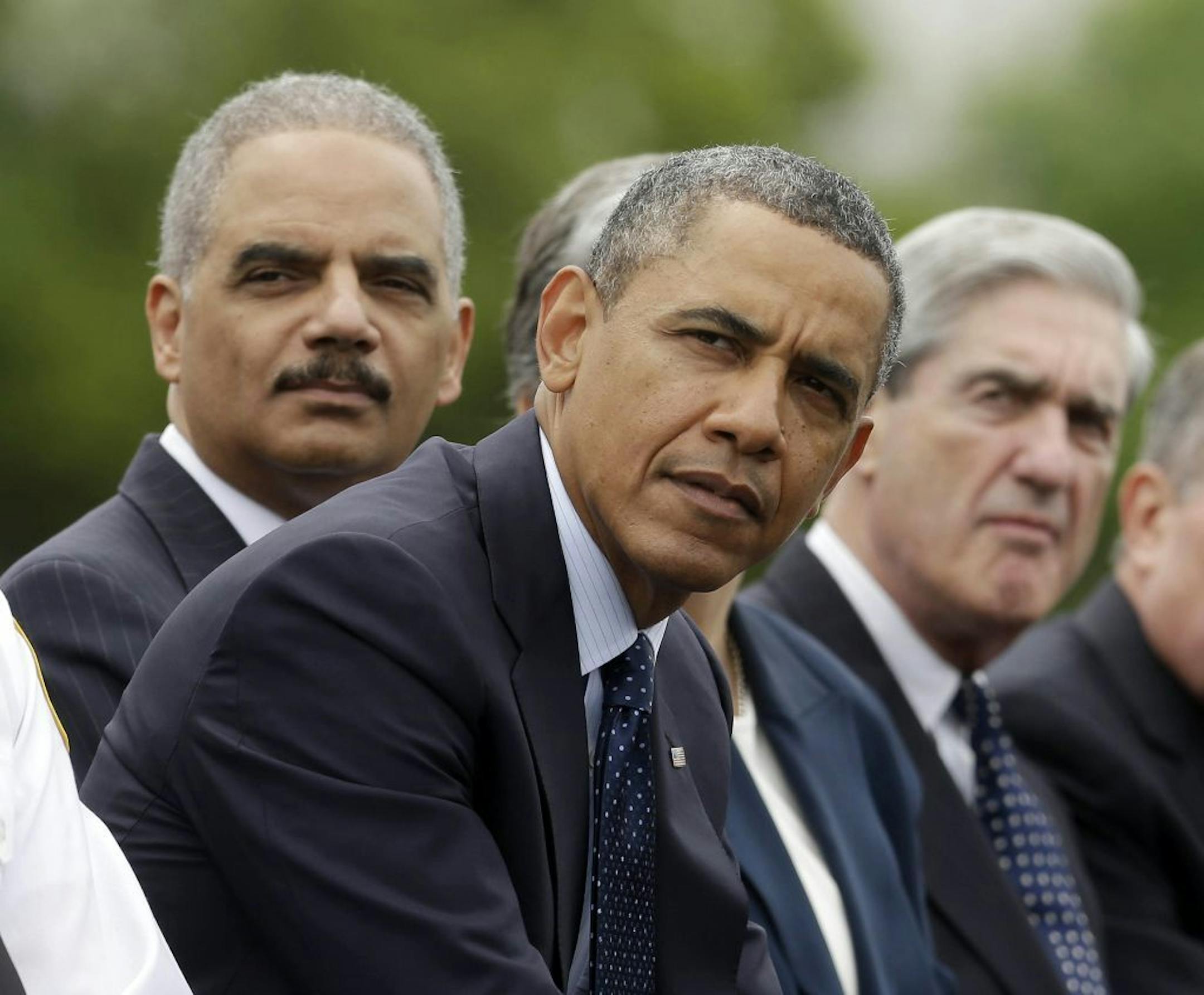 President Barack Obama sits with Attorney General Eric Holder, left, and FBI Director Robert Mueller during the 32nd annual the National Peace Officers Memorial Service, Wednesday, May 15, 2013, on Capitol Hill in Washington, honoring law enforcement officers who died in the line of duty.