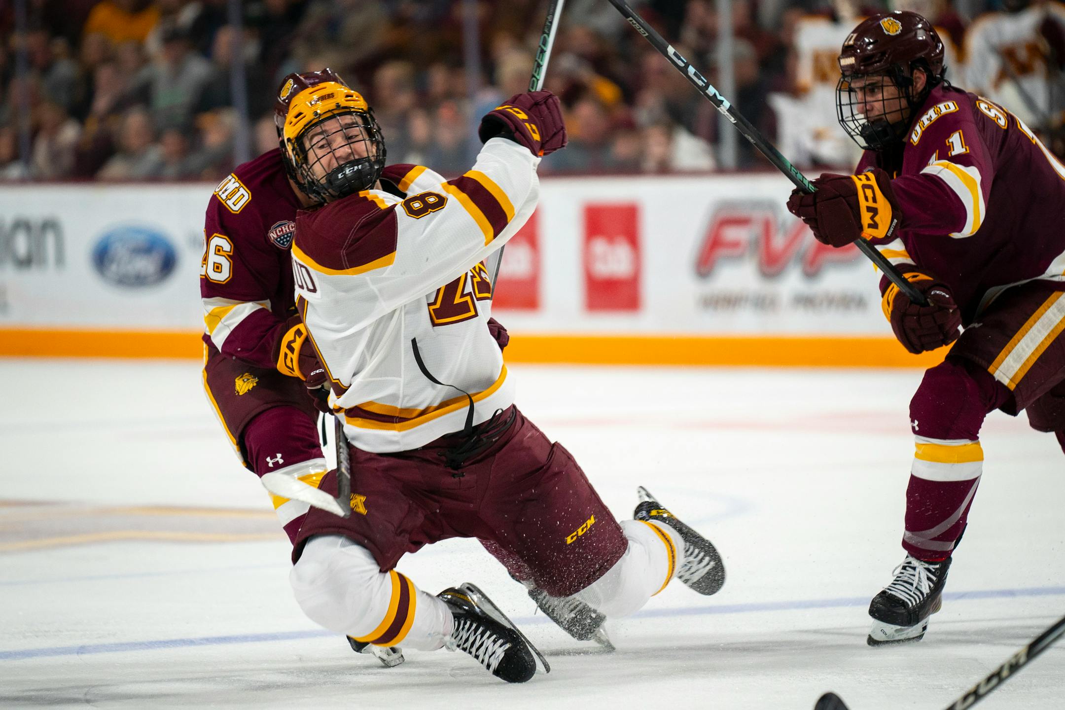 Minnesota forward Mason Nevers (18) falls over Duluth Right Wing Kyle Betten's (24) stick.