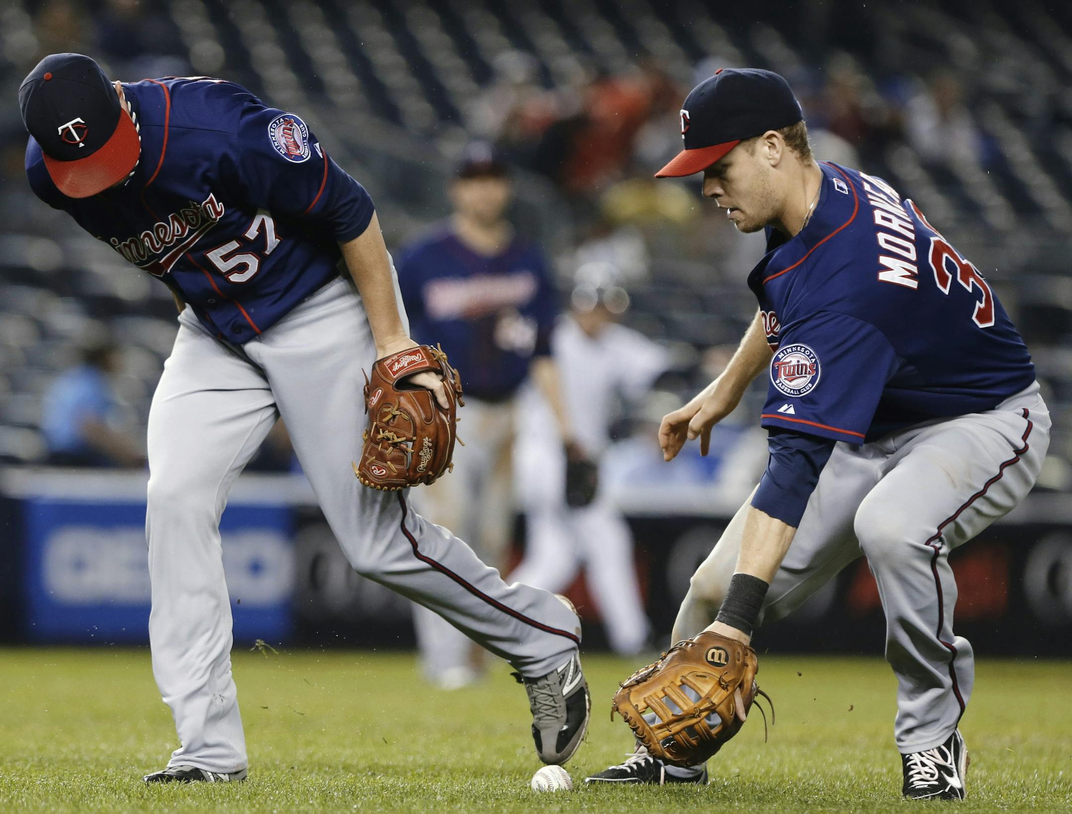 Minnesota Twins relief pitcher Ryan Pressly (57) and first baseman Justin Morneau (33) chase down a sacrifice bunt by New York Yankees' Chris Stewart in the fifth inning of a baseball game Friday, July 12, 2013, in New York. (AP Photo/Frank Franklin II)