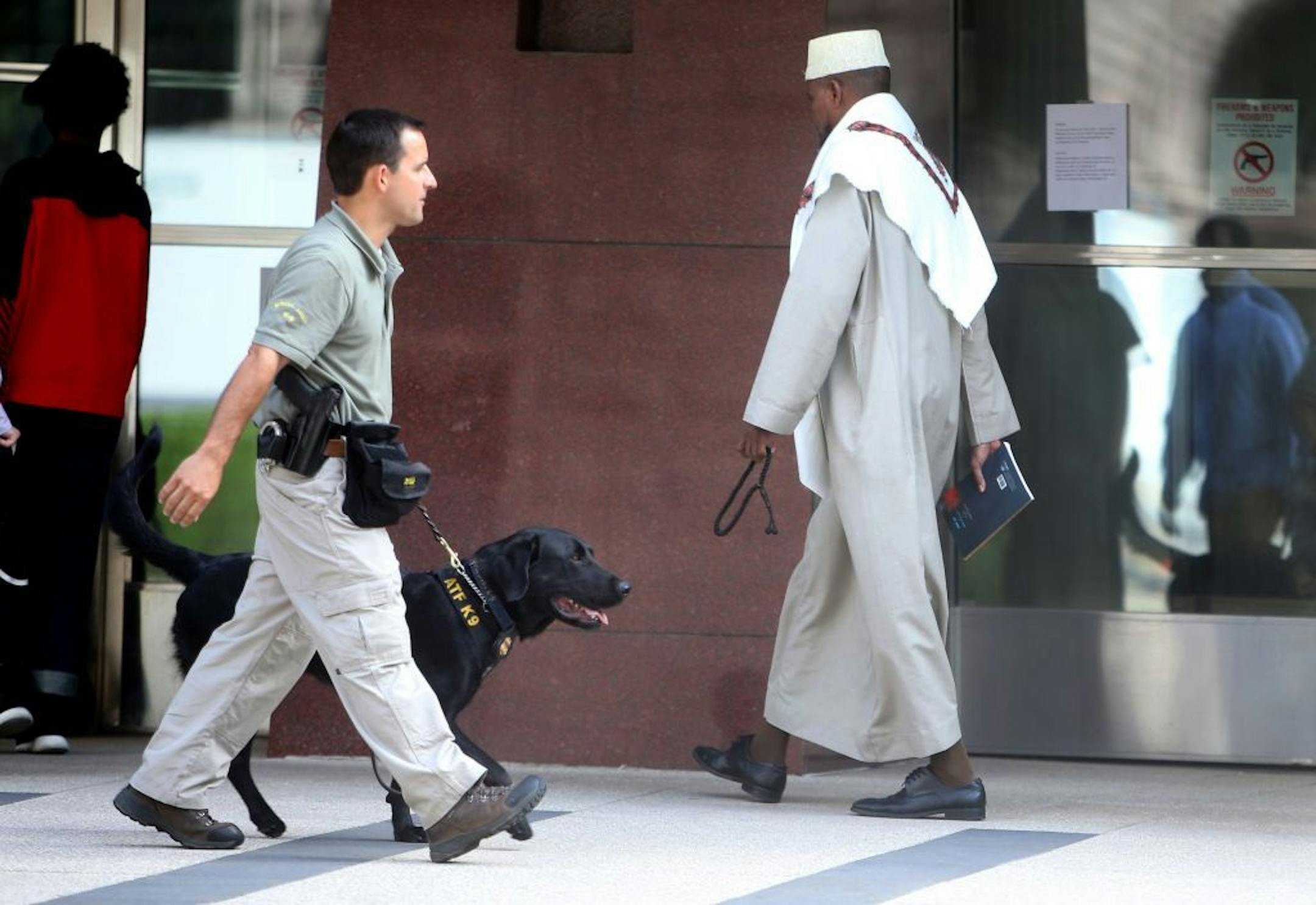 A Muslim cleric walks toward the courthouse for a pretrial hearing for three local men accused of conspiring to leave the country to support or join ISIL Wednesday, July 8, 2015, in Minneapolis, MN. A large police presence was visible outside the courthouse.