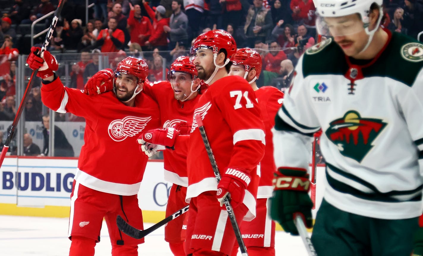 Detroit Red Wings left wing David Perron, center, celebrates his goal against the Minnesota Wild with defenseman Shayne Gostisbehere (41) and left wing J.T. Compher (37) during the first period of an NHL hockey game Sunday, Nov. 26, 2023, in Detroit. (AP Photo/Duane Burleson)