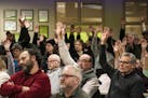 Those who approved a motion to refuse refugee resettlement raised their hands in the overcapacity crowd in attendance.] Beltrami County is the latest 